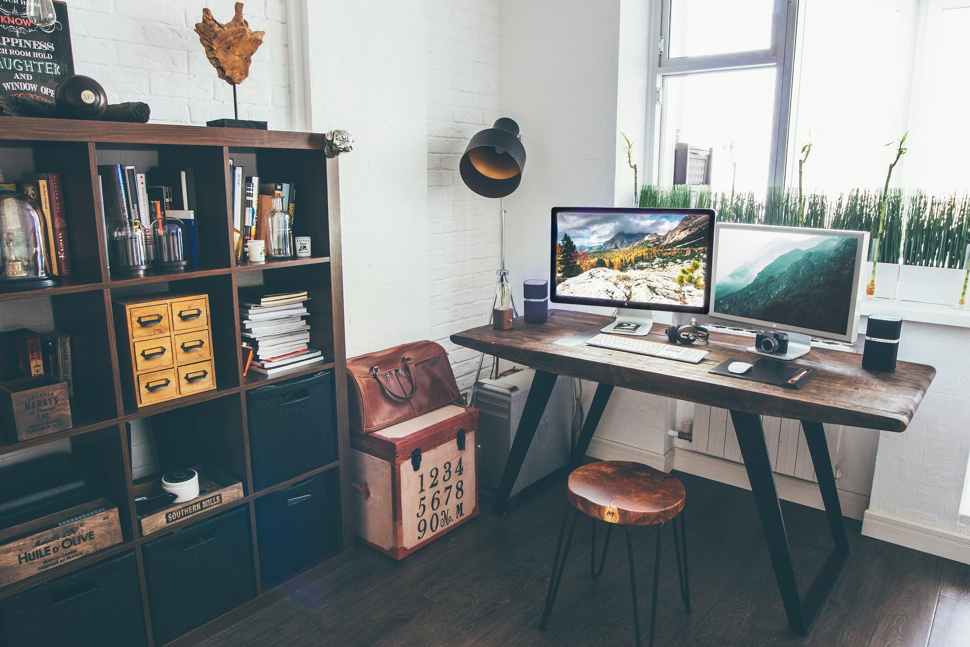 Petit bureau individuel avec deux écrans, une étagère et une chaise